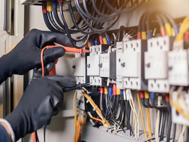 Eldivenli elektrik teknisyeni pano bağlantısı yaparken